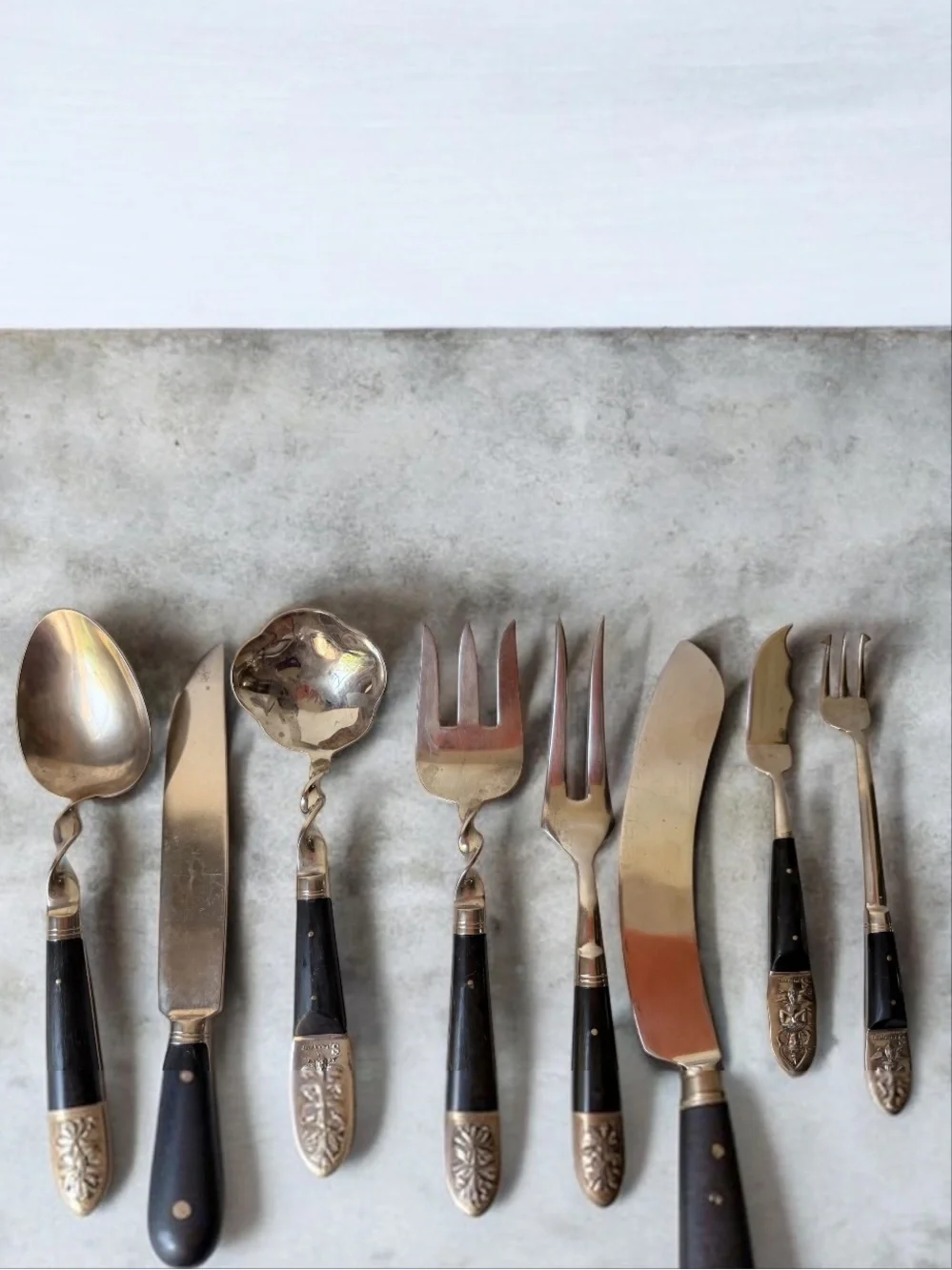 set consists of vintage Thai brass or bronze utensils with dark wooden handles.